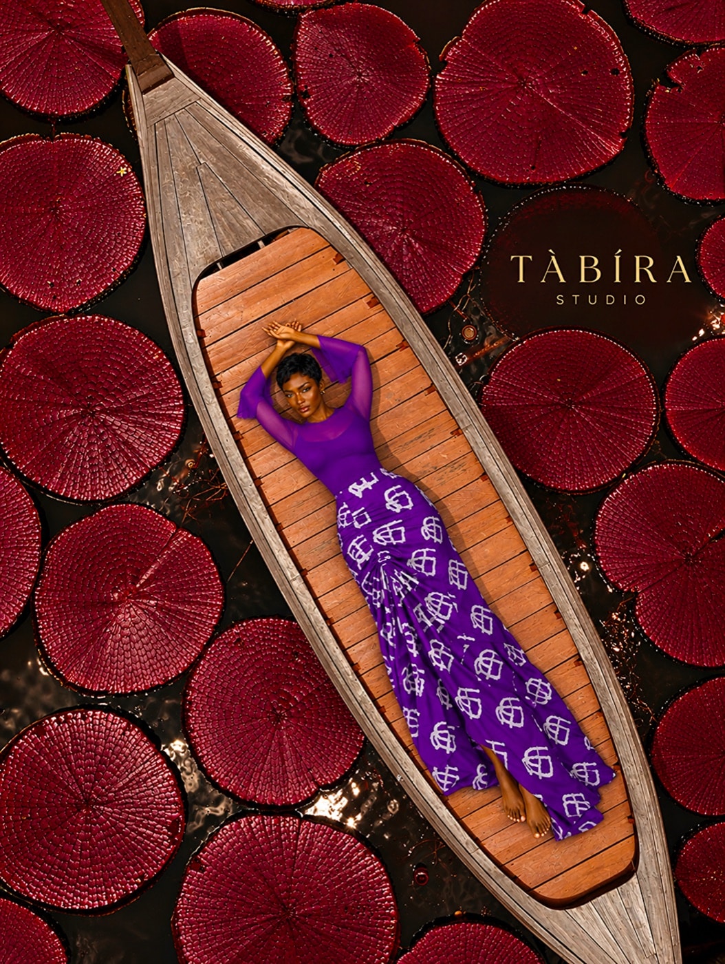 TÀBÍRA Studio purple monogram print outfit photographed on a wooden boat among red fans
